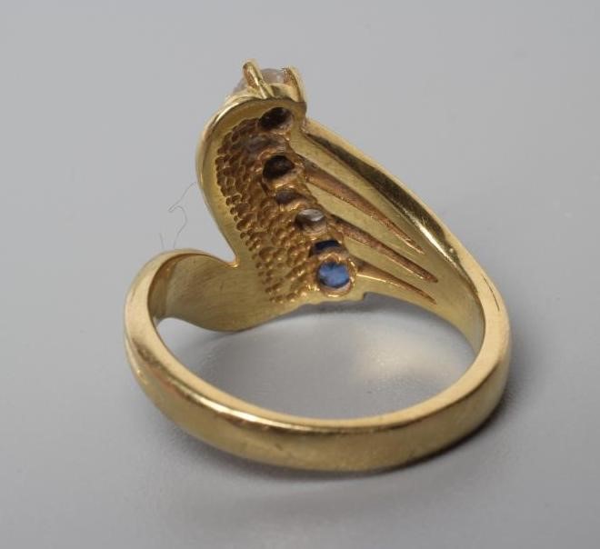 A FOUR STONE SAPPHIRE AND DIAMOND CROSSOVER DRESS RING Image