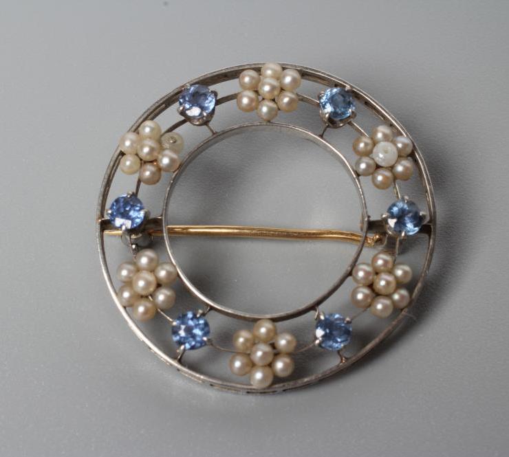 AN EDWARDIAN SAPPHIRE AND SEED PEARL CIRCLET BROOCH Image