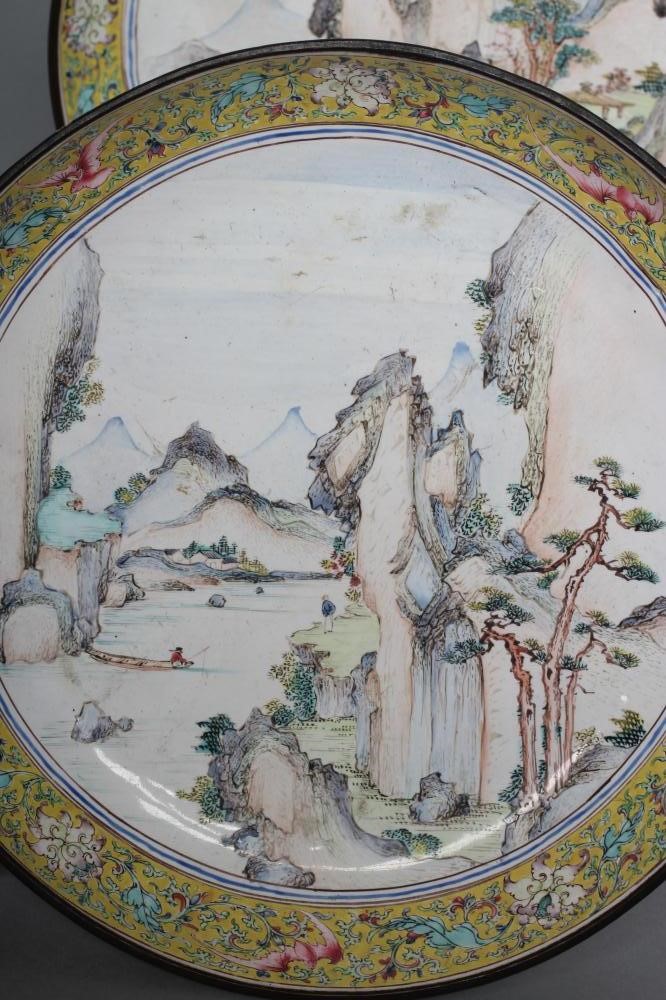 A PAIR OF CANTON ENAMEL SAUCER DISHES centrally painted in pastel colours with figures in extensive Image