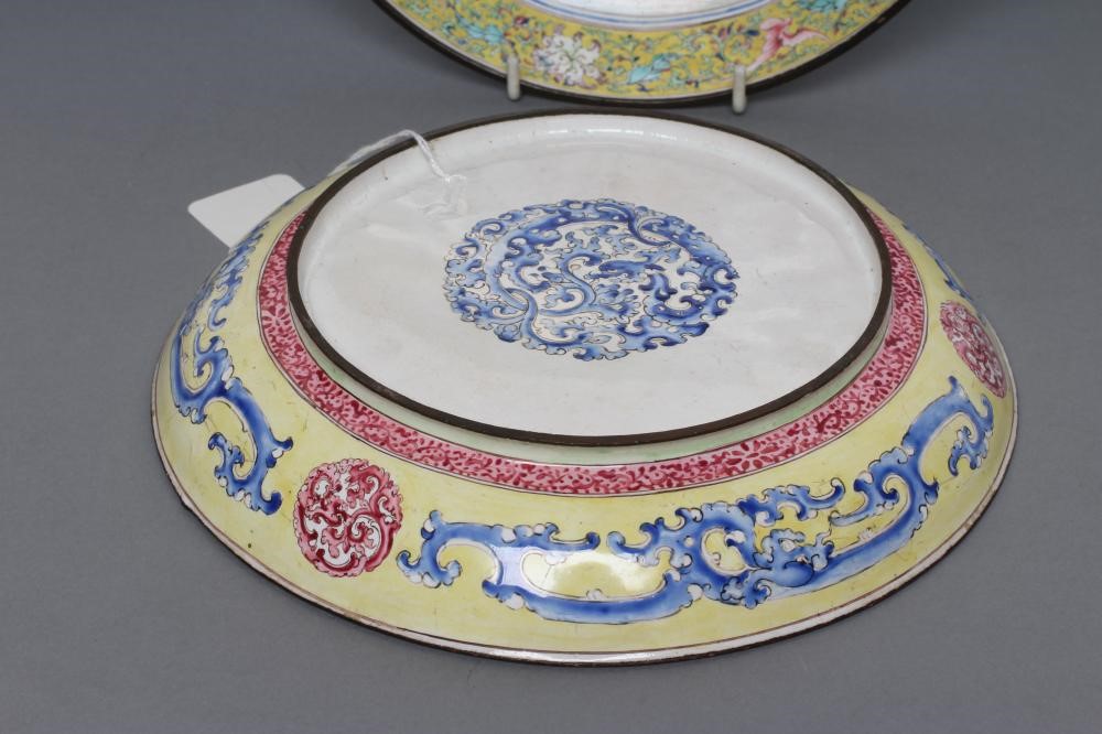 A PAIR OF CANTON ENAMEL SAUCER DISHES centrally painted in pastel colours with figures in extensive Image