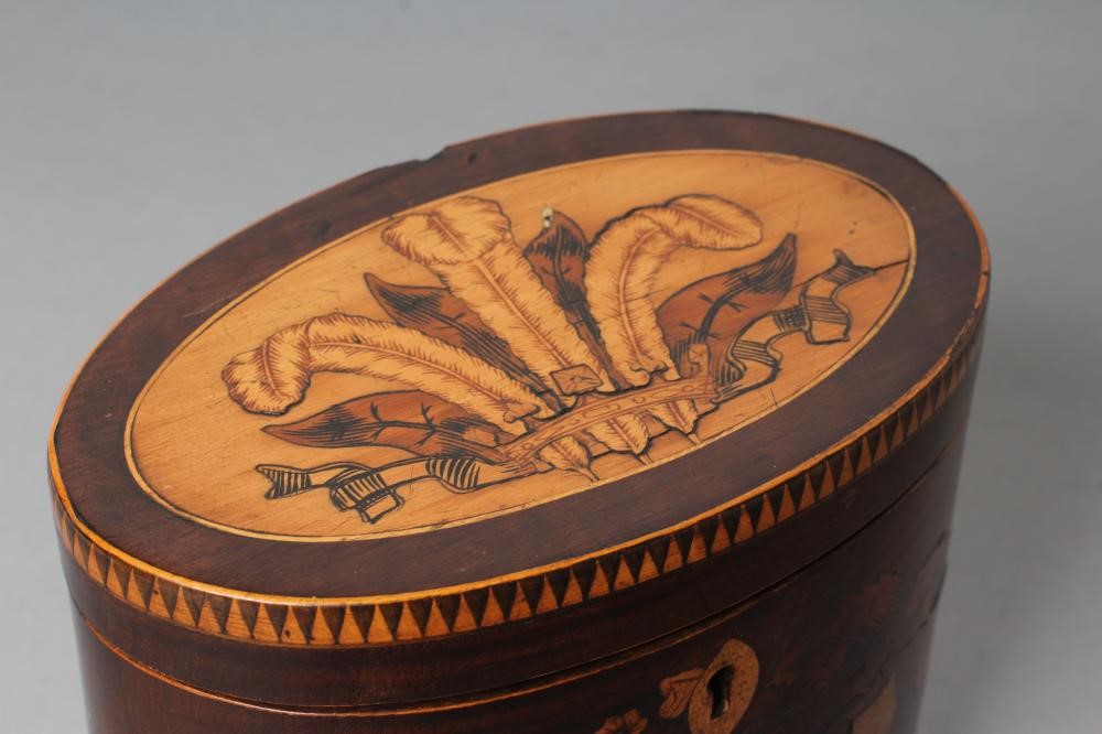 A REGENCY MAHOGANY TEA CADDY of oval form with ribbon tied marquetry flowers and berried branches Image