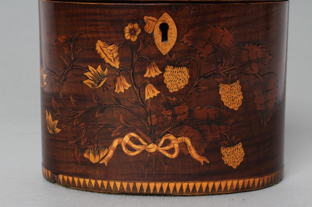 A REGENCY MAHOGANY TEA CADDY of oval form with ribbon tied marquetry flowers and berried branches Image