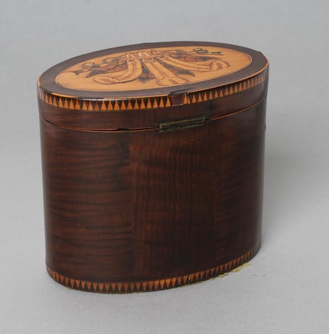 A REGENCY MAHOGANY TEA CADDY of oval form with ribbon tied marquetry flowers and berried branches Image