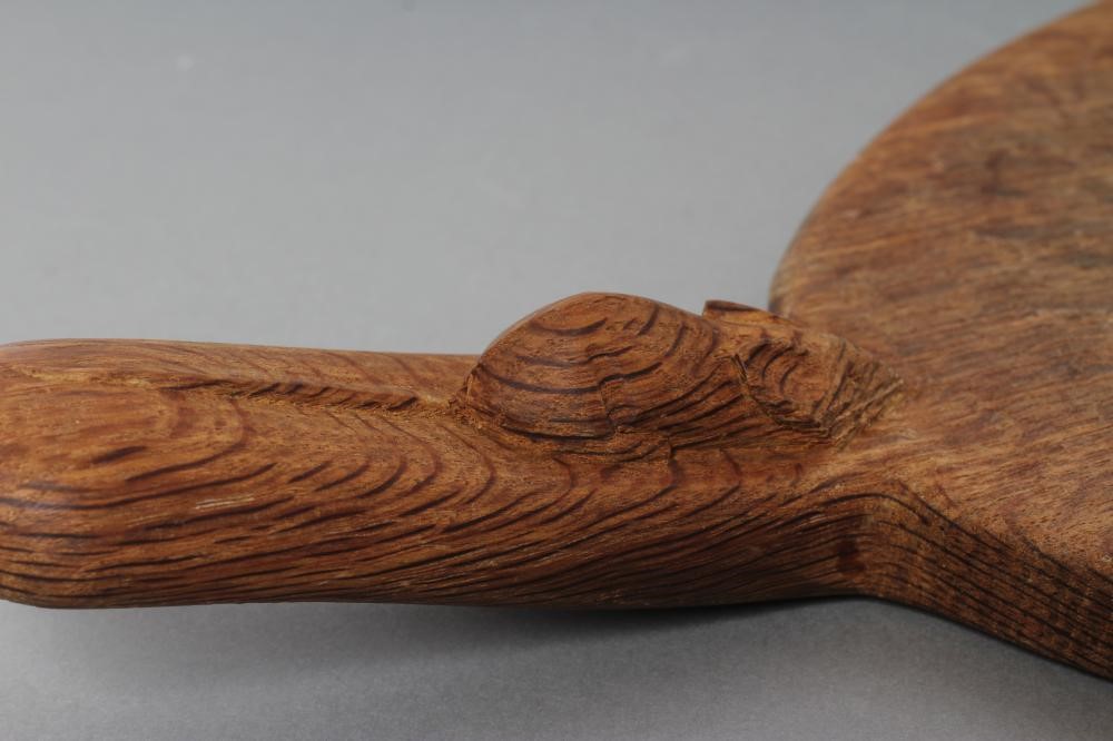 A ROBERT THOMPSON OAK CHEESE BOARD of oval form with carved mouse trademark in high relief to the Image