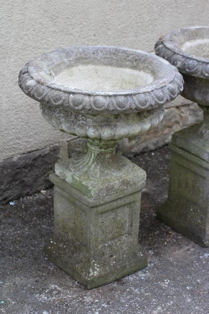A PAIR OF HADDONSTONE STONE URNS of half fluted campana form with egg and dart rim Image