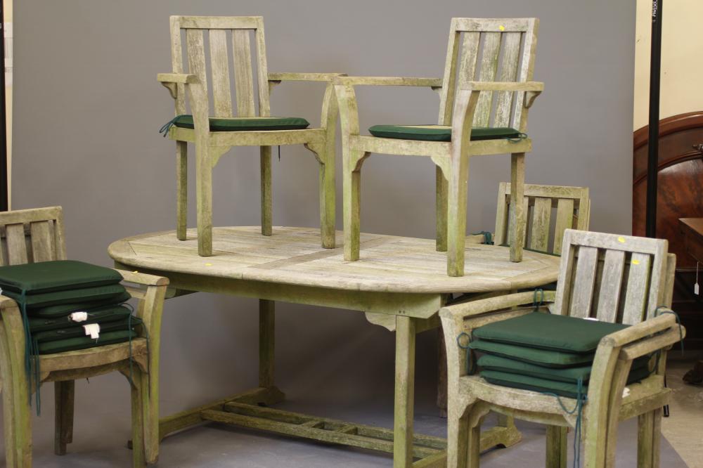 A SLATTED TEAK DINING SUITE comprising an extending dining table of D ended form with central Image