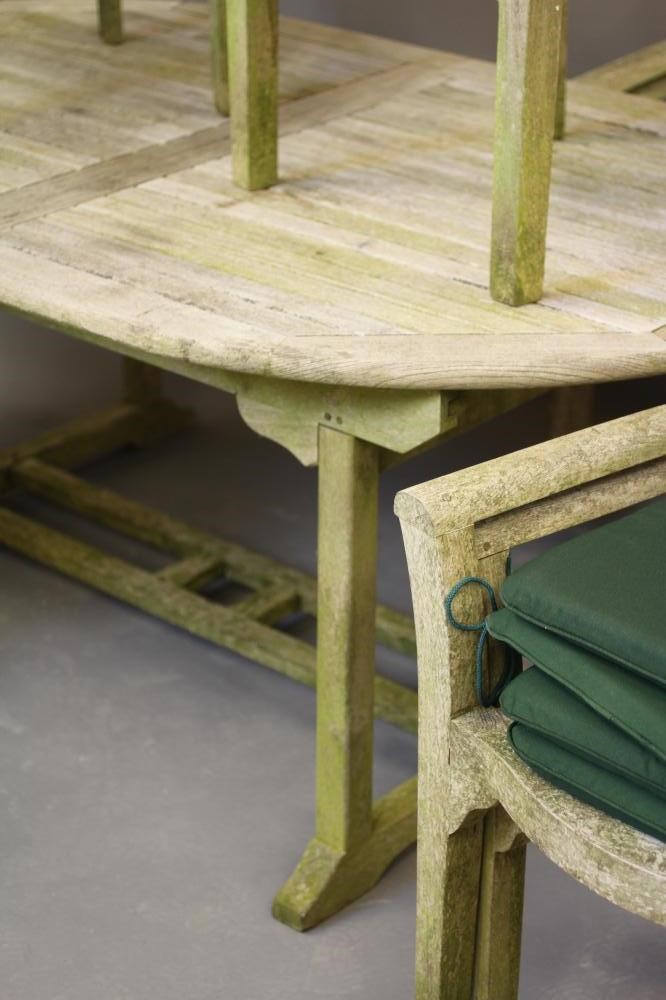 A SLATTED TEAK DINING SUITE comprising an extending dining table of D ended form with central Image