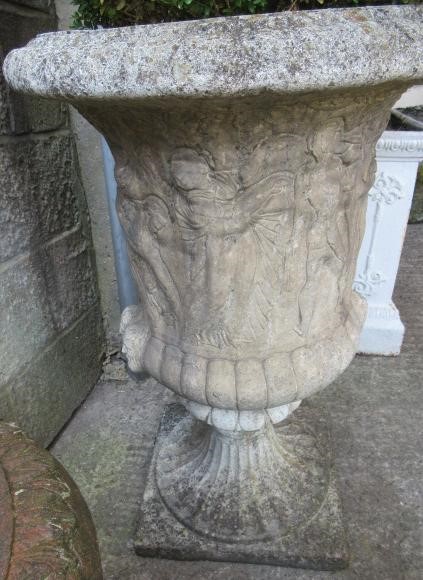 A PAIR OF MEDICI PATTERN COMPOSITION STONE URNS with flared egg and dart rim over a frieze of Image