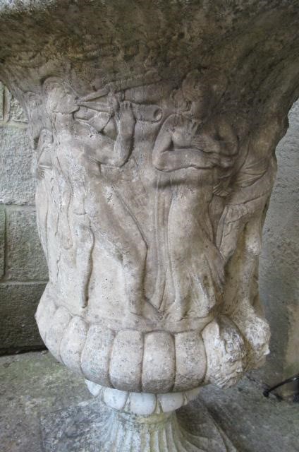 A PAIR OF MEDICI PATTERN COMPOSITION STONE URNS with flared egg and dart rim over a frieze of Image