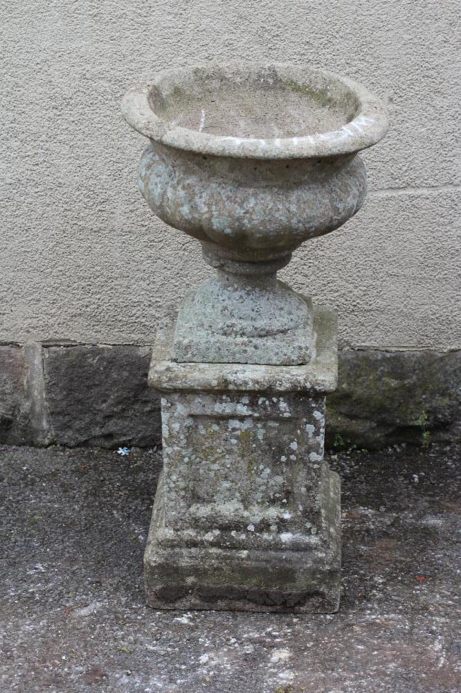 A COMPOSITION STONE URN with fluted body and everted rim Image