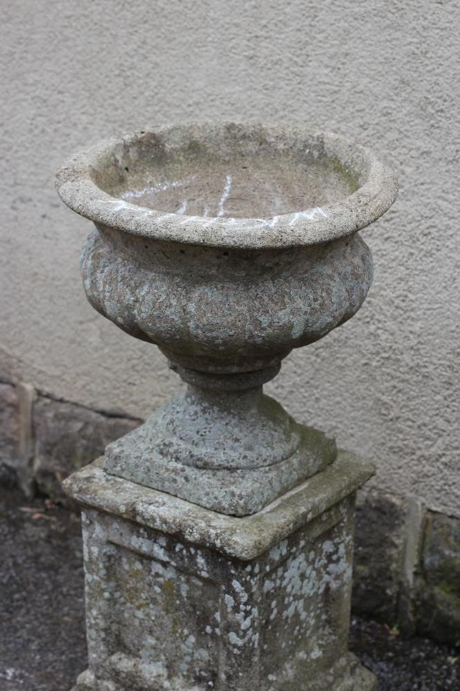 A COMPOSITION STONE URN with fluted body and everted rim Image