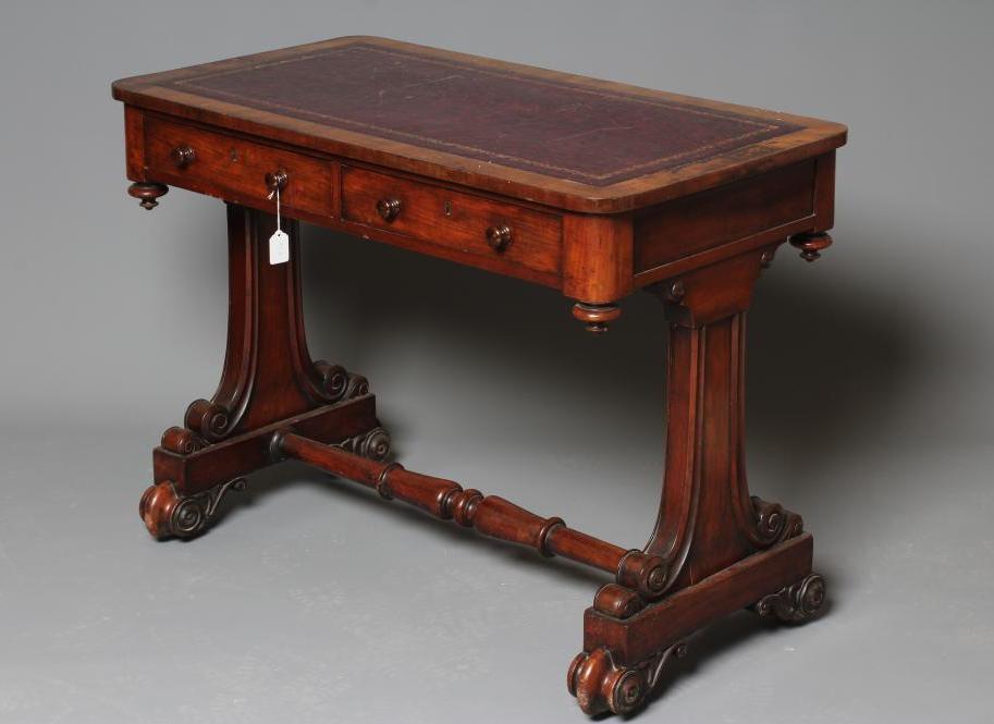 A VICTORIAN MAHOGANY WRITING TABLE of rounded oblong form inset with tooled red leather Image