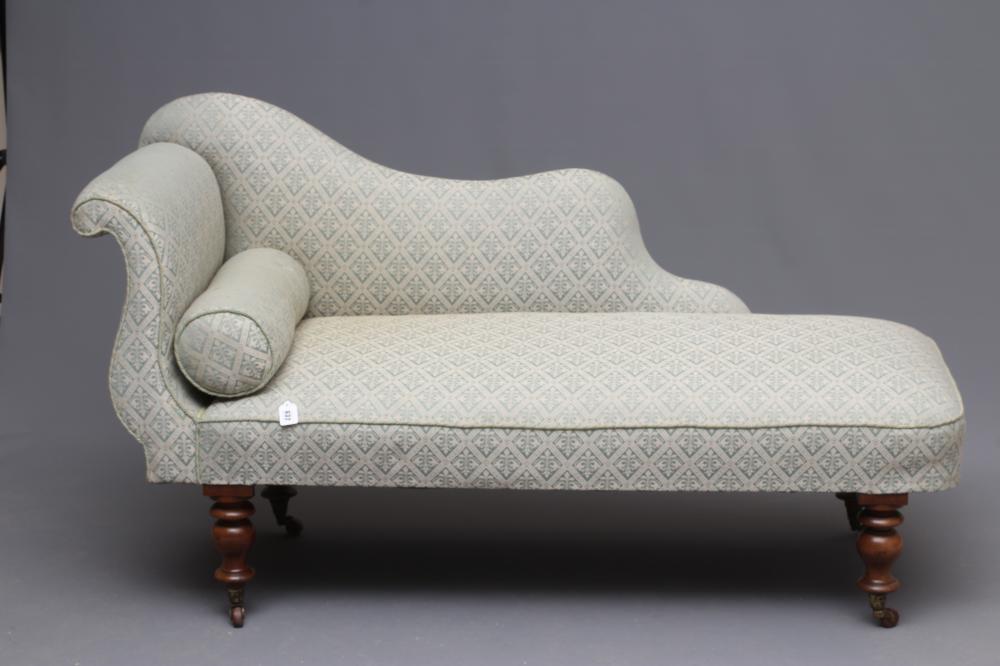 A VICTORIAN WALNUT FRAMED CHAISE LONGUE upholstered in a pale green trellis pattern weave Image