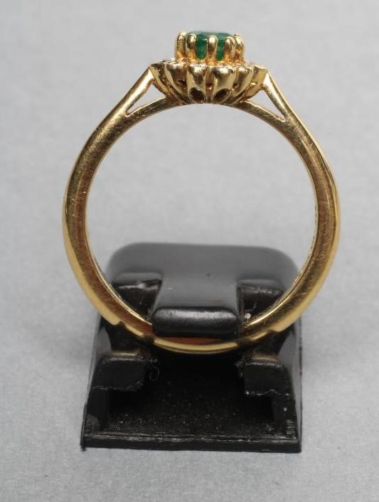 AN EMERALD AND DIAMOND CLUSTER RING Image