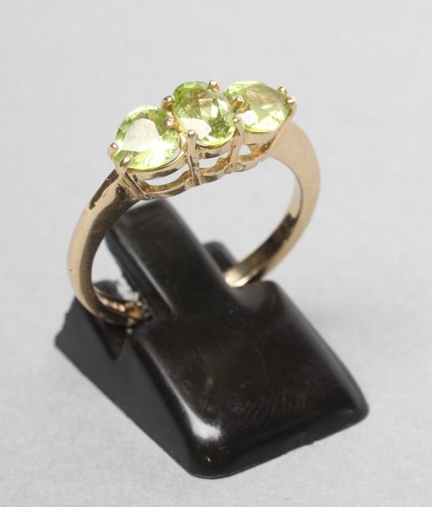 A THREE STONE PERIDOT RING Image