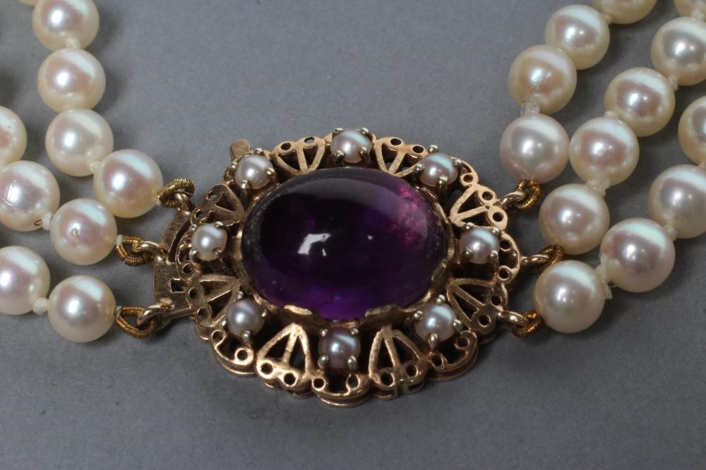 A TRIPLE STRAND CULTURED PEARL NECKLACE Image