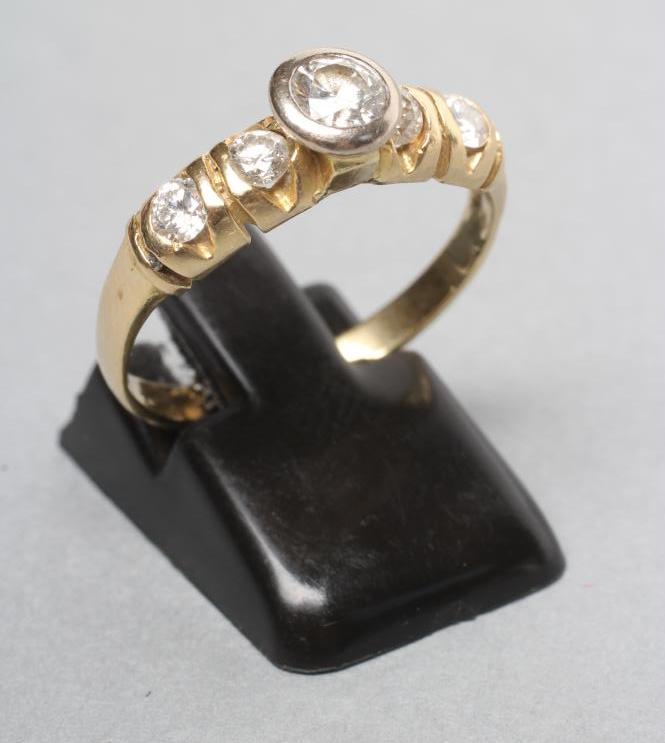 A DIAMOND RING centred by a bezel set stone of approximately 0 Image