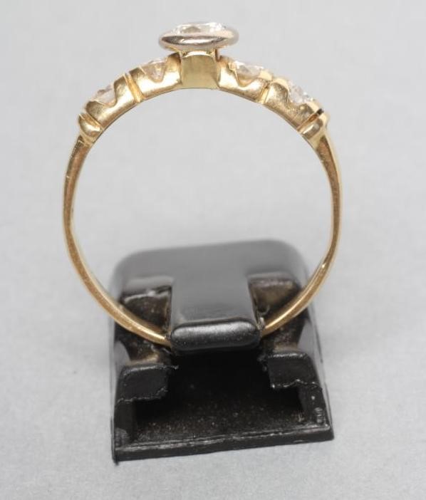 A DIAMOND RING centred by a bezel set stone of approximately 0 Image