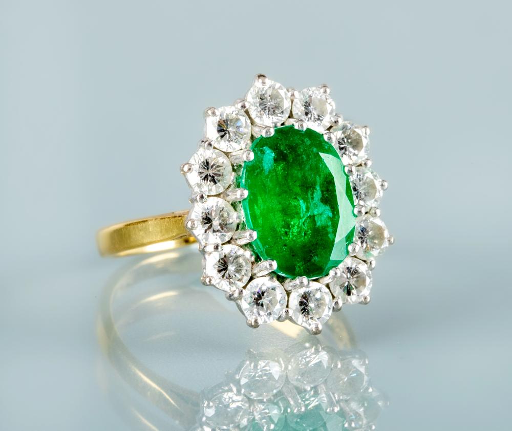 AN EMERALD AND DIAMOND CLUSTER RING Image