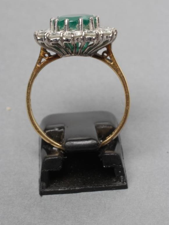 AN EMERALD AND DIAMOND CLUSTER RING Image