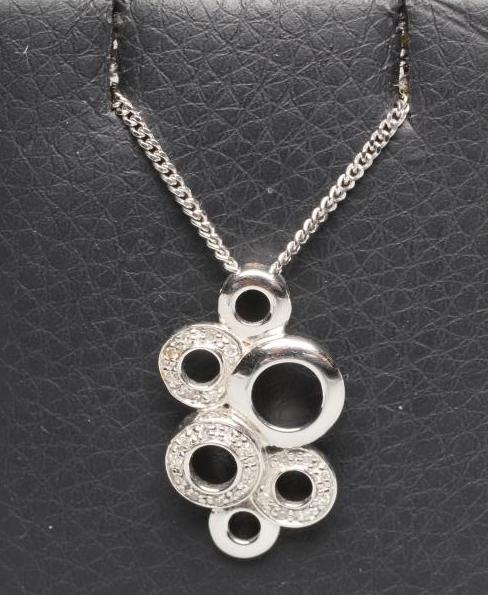 A DIAMOND SET ABSTRACT PENDANT made up of six differing open circular panels Image