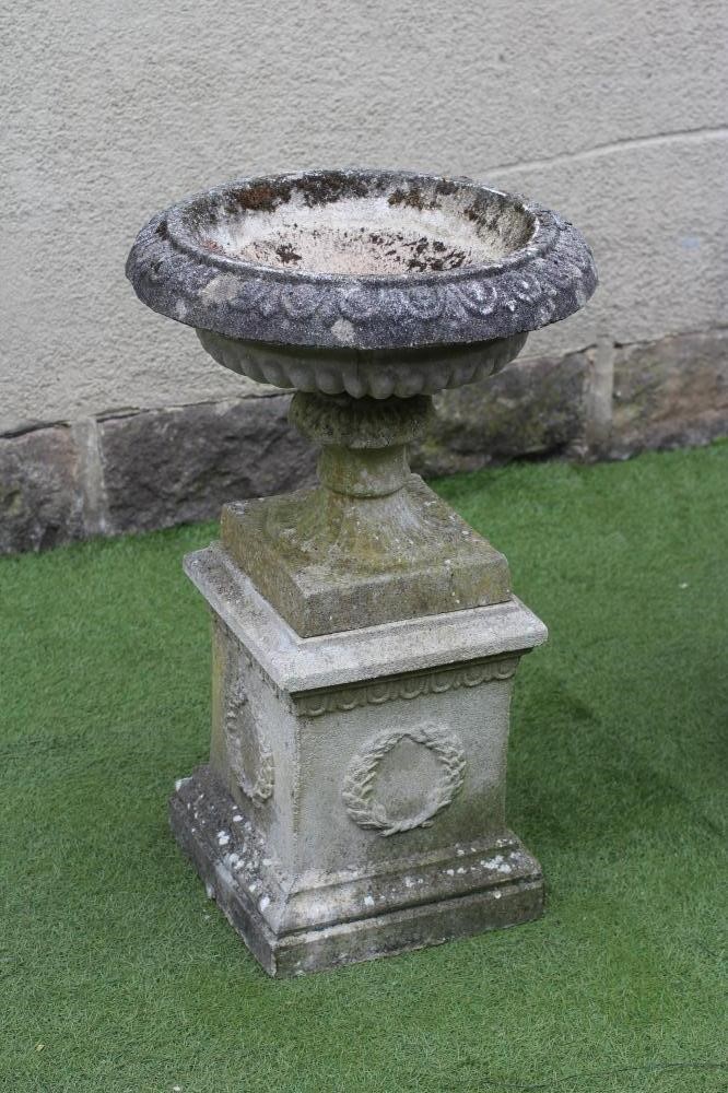 A PAIR OF COMPOSITION STONE URNS Image