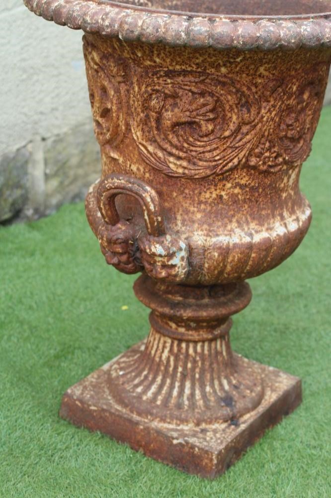 A VICTORIAN CAST IRON URN of half fluted campana form with beaded rim and mask loop handles Image