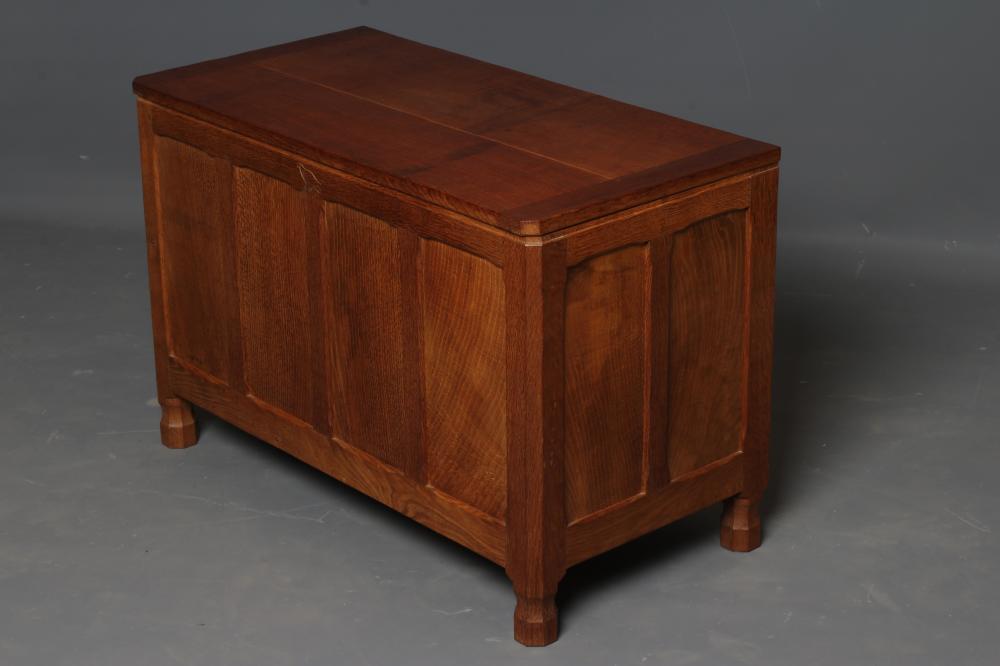 AN ALBERT JEFFRAY ADZED OAK PANELLED CHEST of canted oblong form with hinged plank lid Image