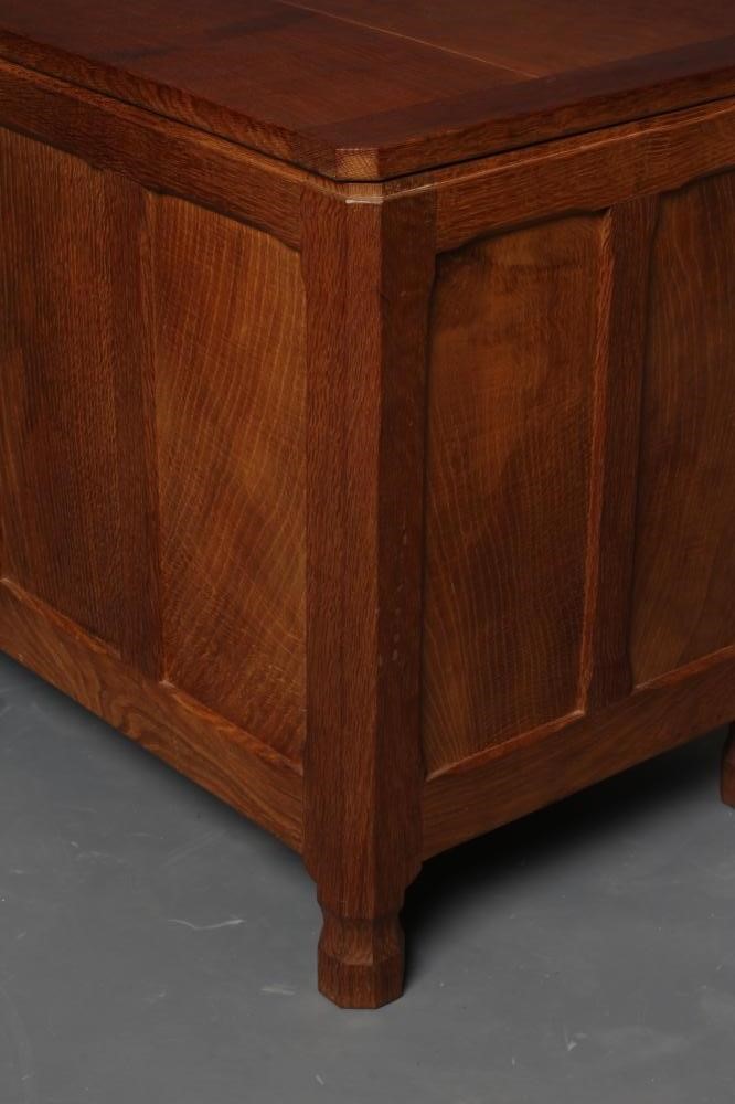 AN ALBERT JEFFRAY ADZED OAK PANELLED CHEST of canted oblong form with hinged plank lid Image