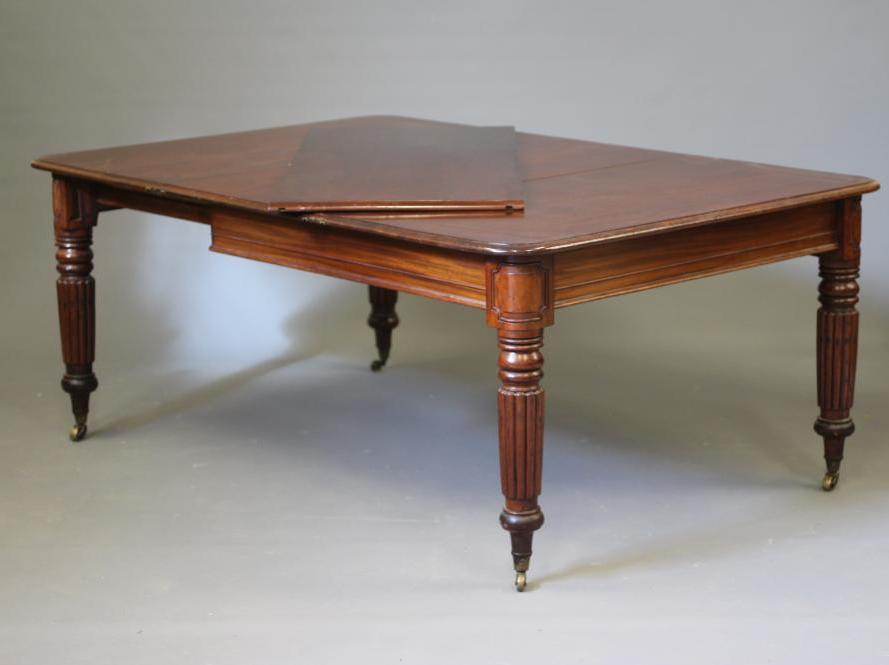 A VICTORIAN EXTENDING MAHOGANY DINING TABLE of rounded oblong form with two leaves and pull out Image