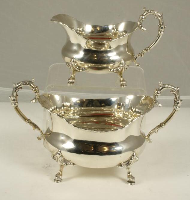 AN EDWARDIAN SILVER TWO HANDLED SUGAR BASIN AND MATCHING CREAM JUG Image