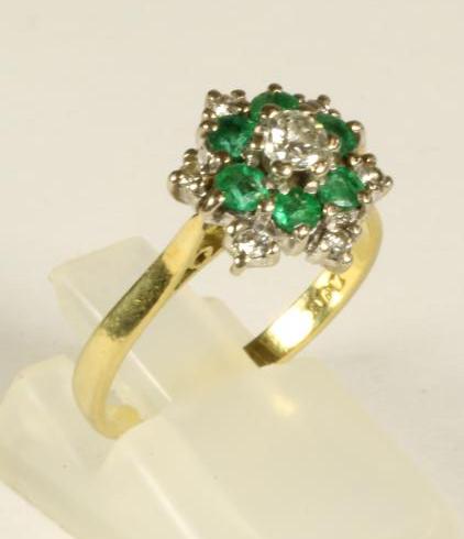 A DIAMOND AND EMERALD CLUSTER RING Image
