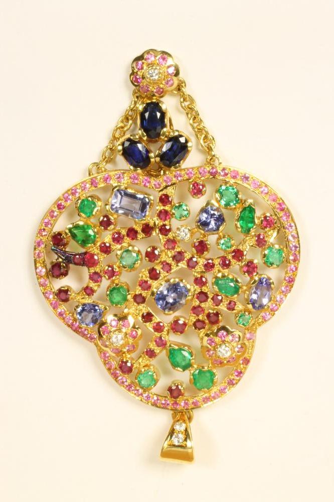 A MULTI-GEM PENDANT of open trefoil form claw set with emeralds Image