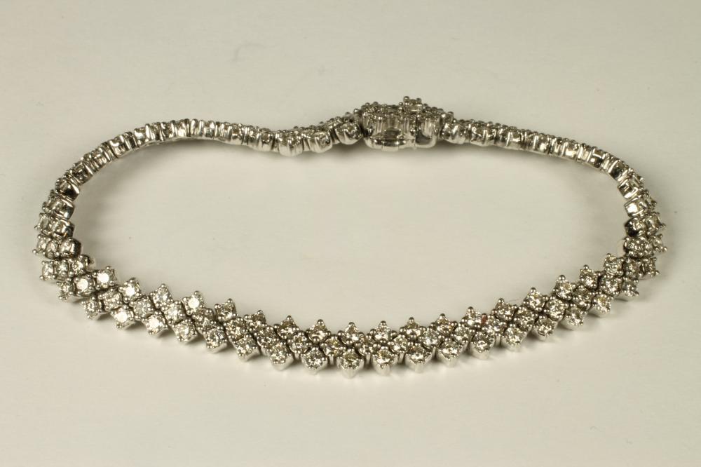 A DIAMOND BRACELET made up of forty seven quatrefoil panels each claw set with four brilliant cut Image