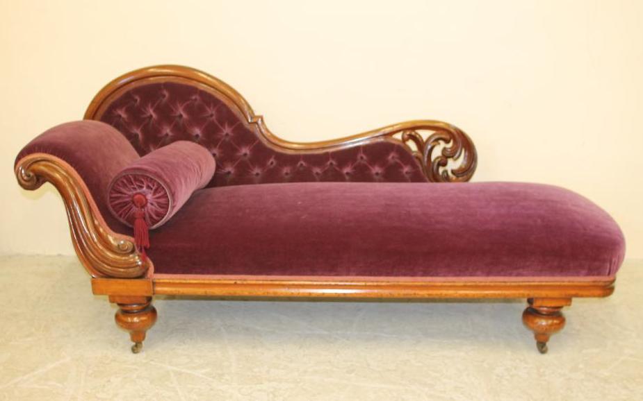 A VICTORIAN WALNUT FRAMED CHAISE LONGUE button upholstered in purple velvet Image