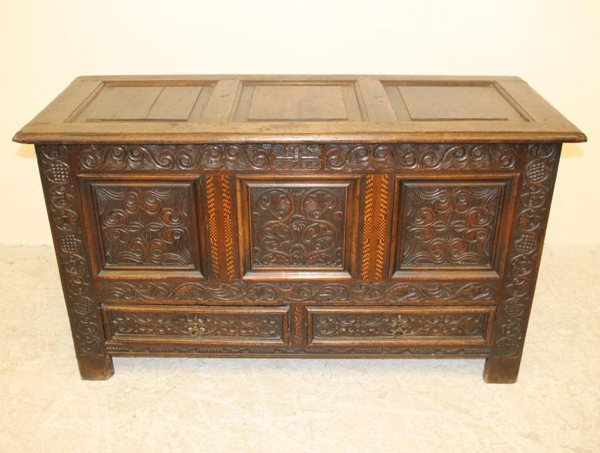 AN OAK CARVED AND PANELLED CHEST Image