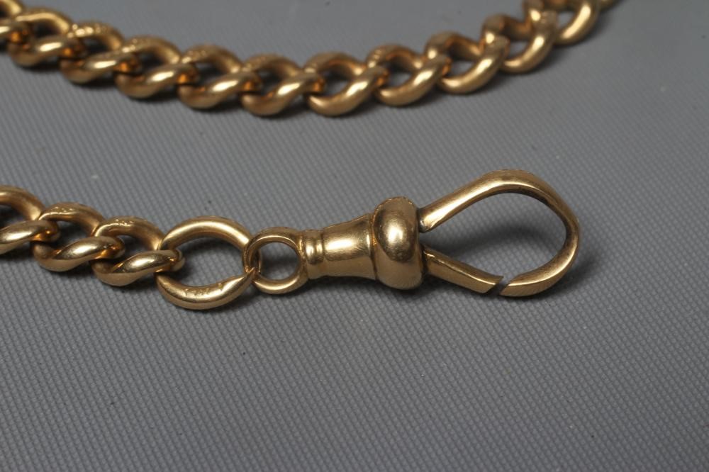 AN 18CT GOLD ALBERT CHAIN, each of the graduating curb links stamped with a crown and 18, with dog Image