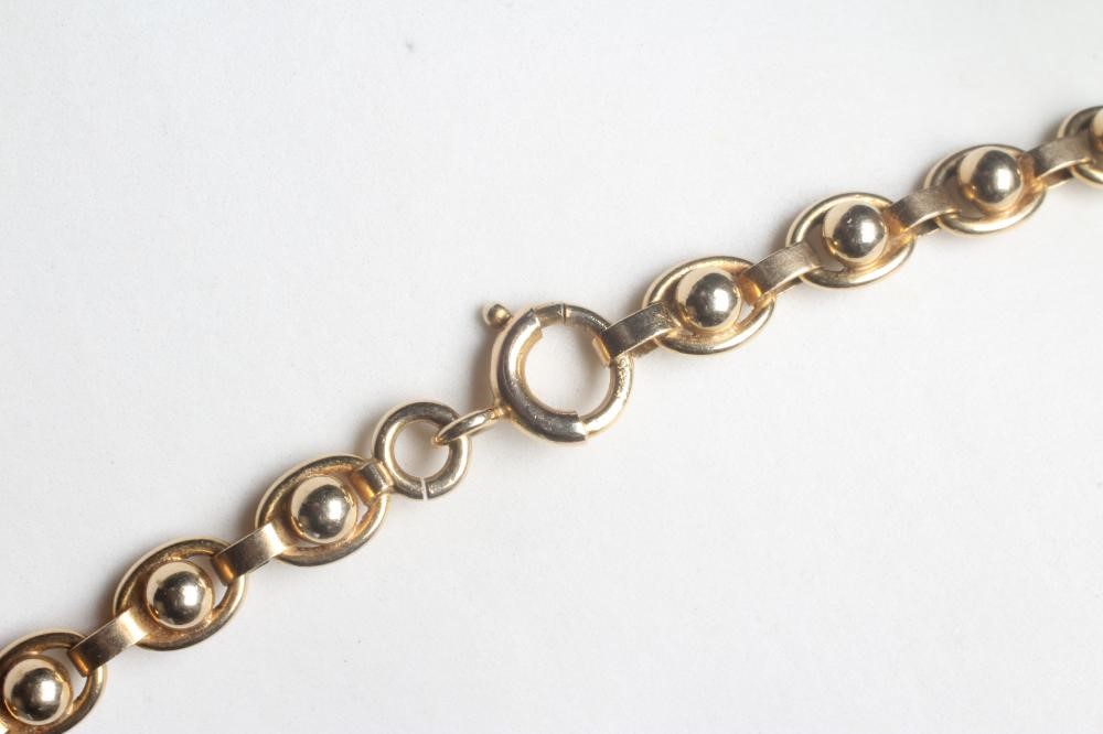 A FANCY LINK CHAIN NECKLACE stamped 375 9, 9K, the ball centred oval links terminating in a larger Image