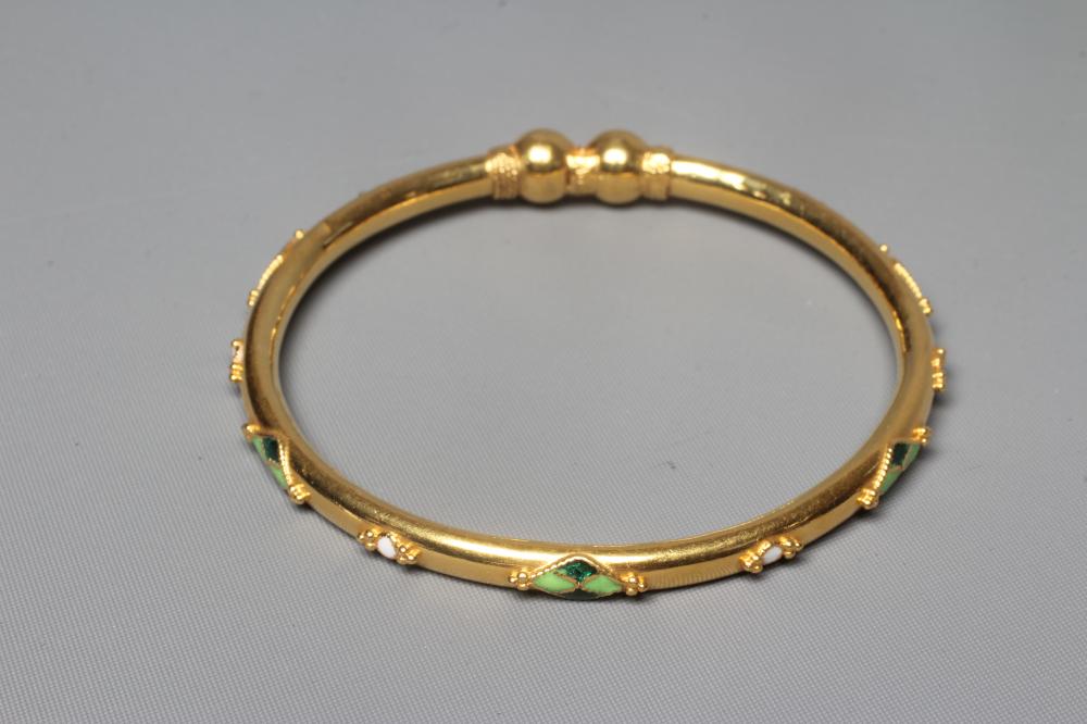 A BANGLE stamped M22K, probably Egyptian, with raised white, green and black lozenge panels and Image