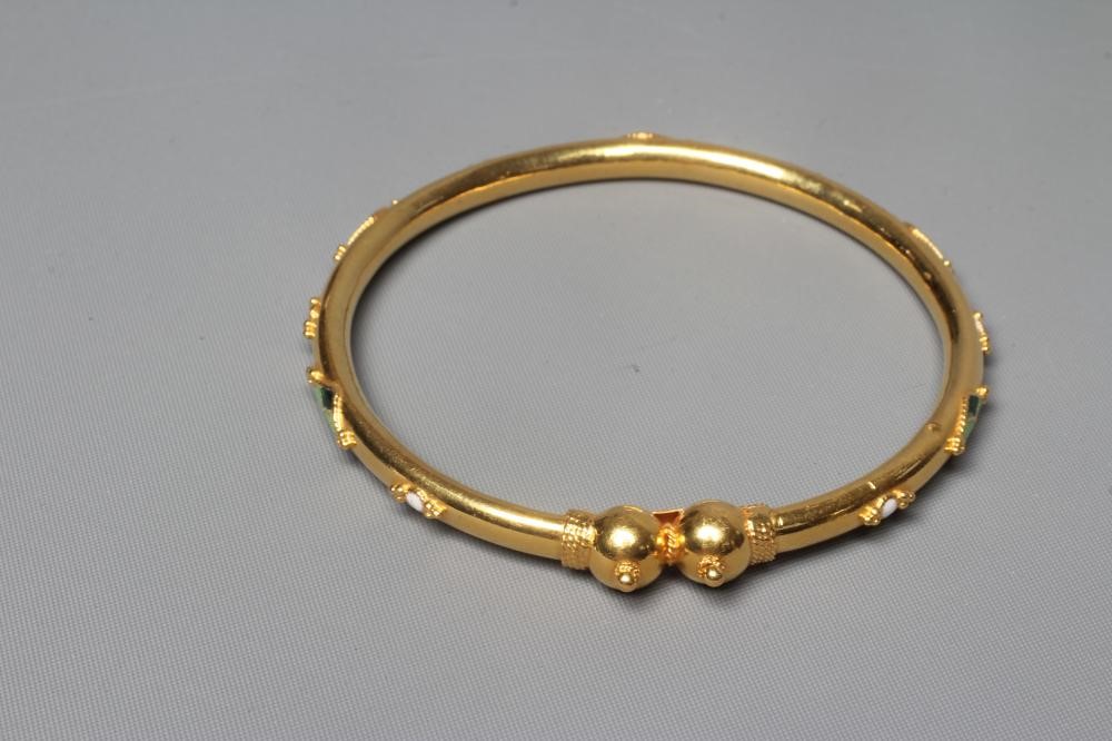 A BANGLE stamped M22K, probably Egyptian, with raised white, green and black lozenge panels and Image