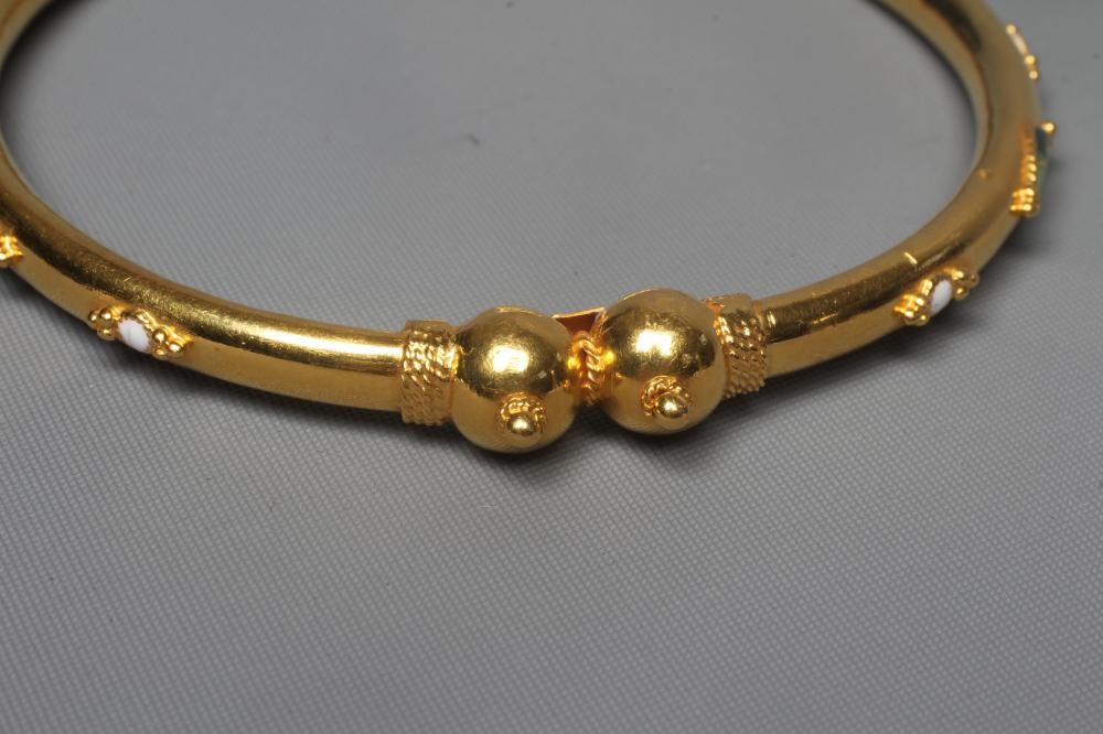 A BANGLE stamped M22K, probably Egyptian, with raised white, green and black lozenge panels and Image