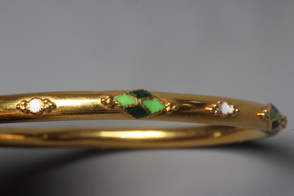 A BANGLE stamped M22K, probably Egyptian, with raised white, green and black lozenge panels and Image