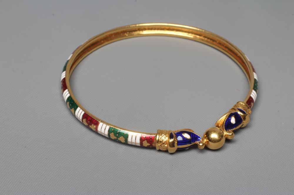 A BANGLE, unmarked but similar to previous lot with red, white and green enamelled arcading and Image