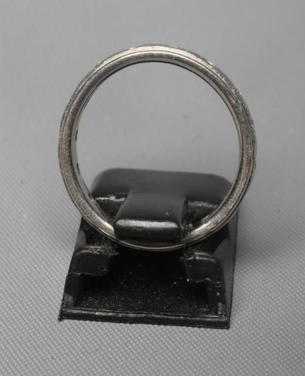 A PLATINUM ETERNITY RING with small diamonds in rub-over settings, London, 5.1g gross, size J 1/2 Image
