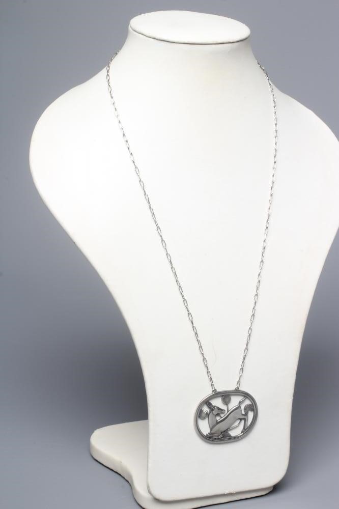 A GEORG JENSEN SILVER OVAL PENDANT designed by Arno Malinowski with a kneeling deer amongst flowers Image