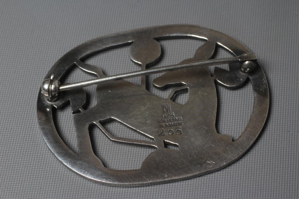 A GEORG JENSEN SILVER OVAL BROOCH designed by Arno Malinowski with a kneeling deer amongst flowers, Image