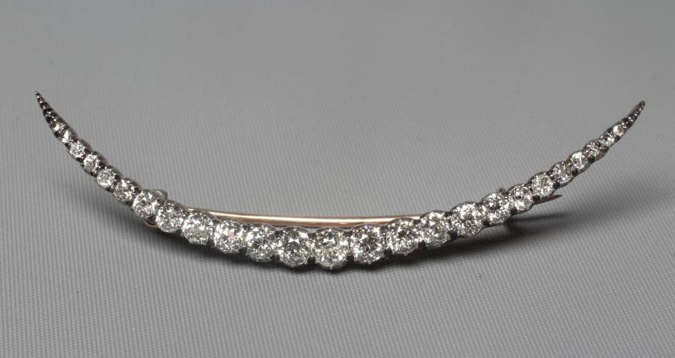 A DIAMOND CRESCENT BROOCH, with twenty old brilliant and five rose cut stones all claw set to an Image