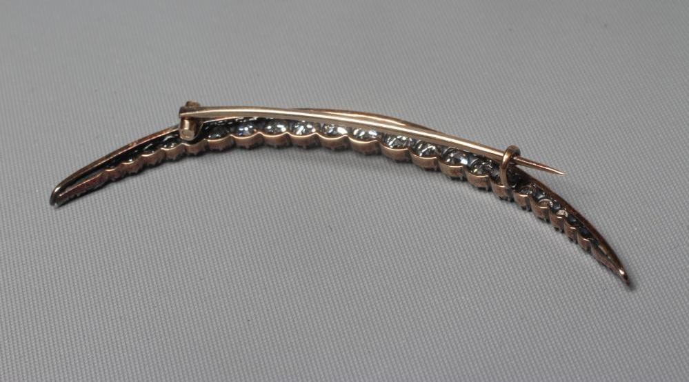 A DIAMOND CRESCENT BROOCH, with twenty old brilliant and five rose cut stones all claw set to an Image