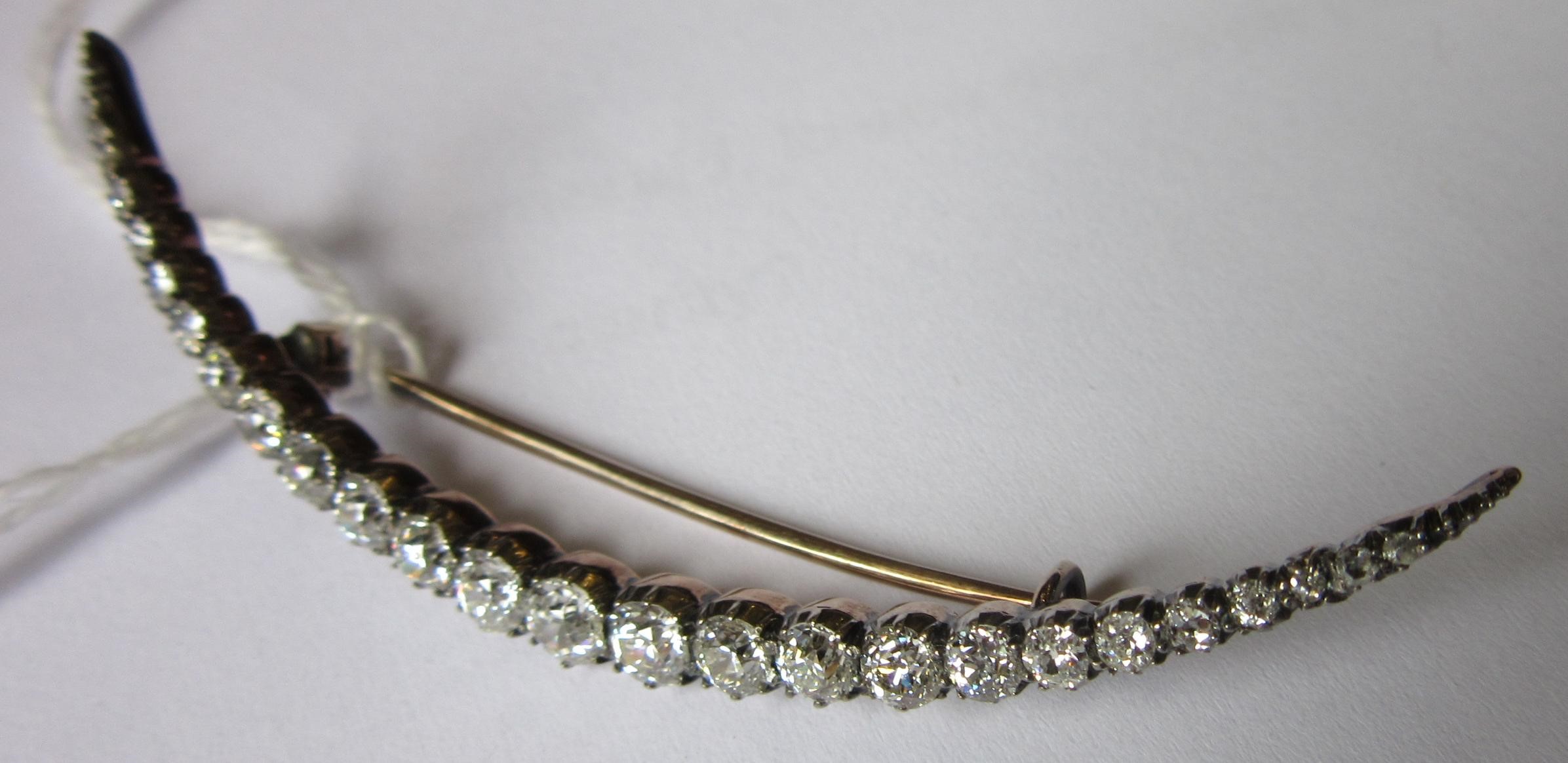 A DIAMOND CRESCENT BROOCH, with twenty old brilliant and five rose cut stones all claw set to an Image