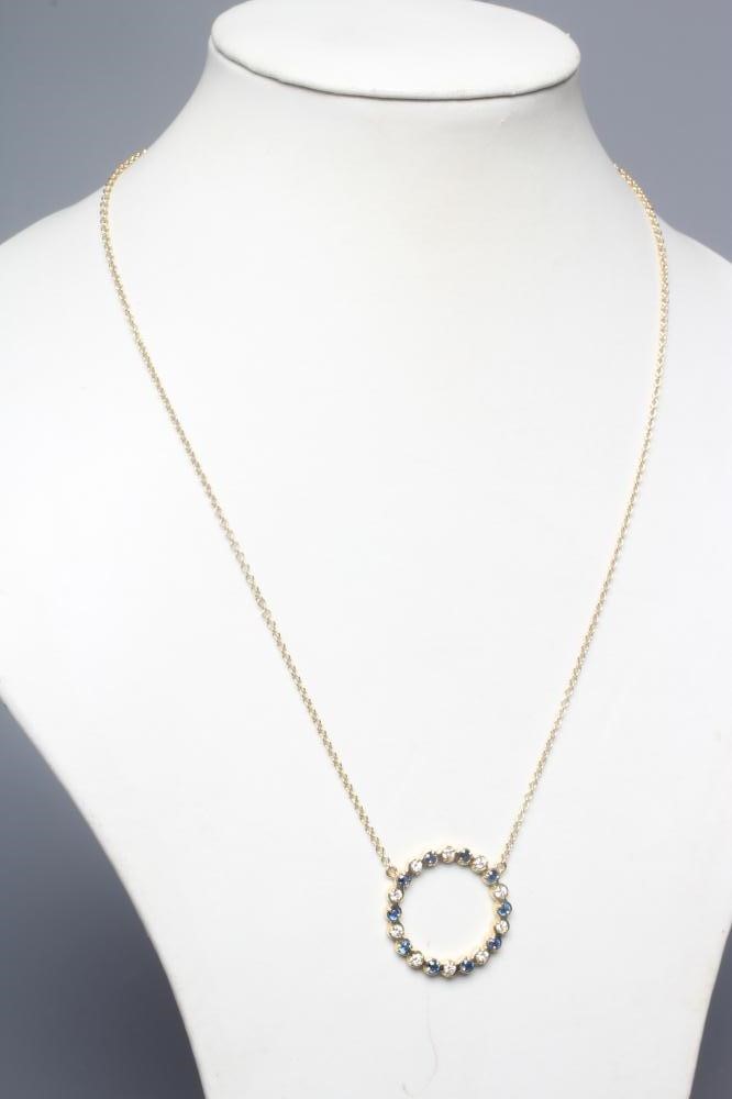 A SAPPHIRE AND DIAMOND OPEN CIRCLET PENDANT alternately set with ten facet cut sapphires and ten Image